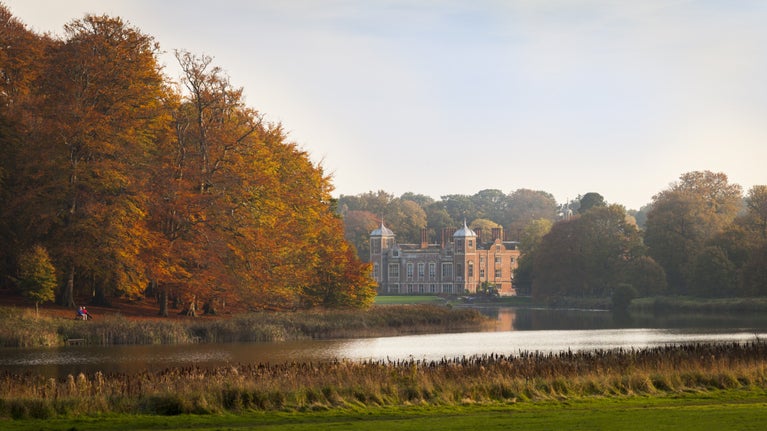 A view of the house Blickling Estate in Norfolk along with the lake and autumnal trees